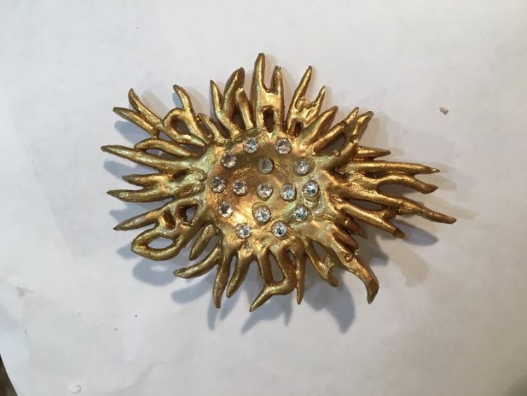 Golden brooch with studded artifical gems